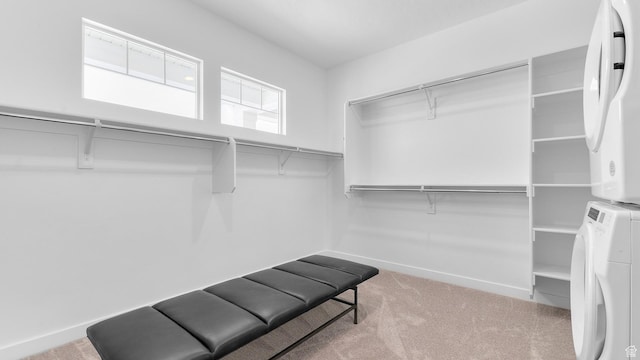 walk in closet featuring stacked washer / drying machine and carpet