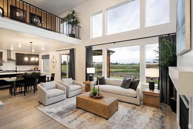 1513 E 820 N Unit 105, Salem, UT 84653 - living area featuring light wood-style floors, a high ceiling, and a chandelier
