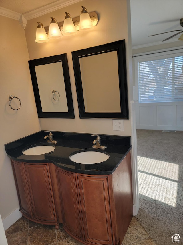 bathroom with crown molding, ceiling fan, and double vanity