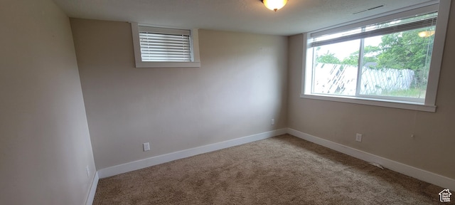 carpeted spare room featuring baseboards