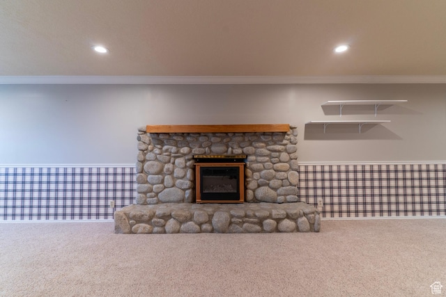 unfurnished living room with ornamental molding, carpet, a stone fireplace, and recessed lighting