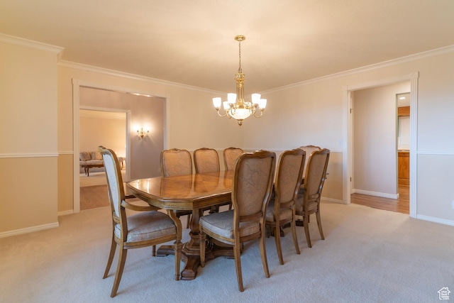 dining area featuring a chandelier, light colored carpet, crown molding, and baseboards