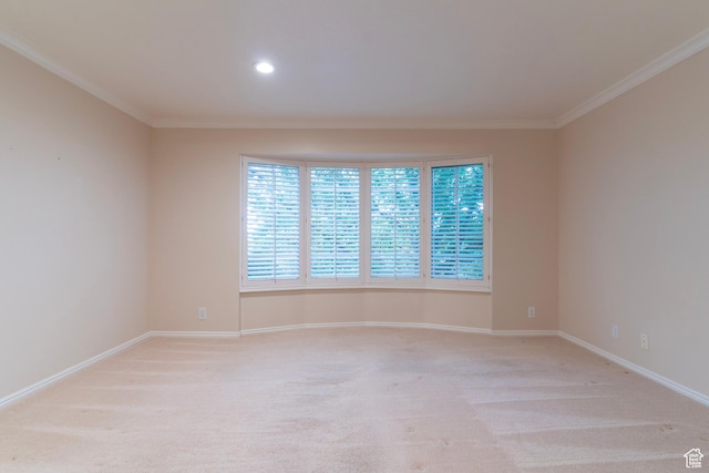 spare room featuring ornamental molding, baseboards, light colored carpet, and recessed lighting