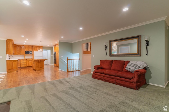 living area with crown molding, baseboards, light colored carpet, recessed lighting, and light wood-style floors