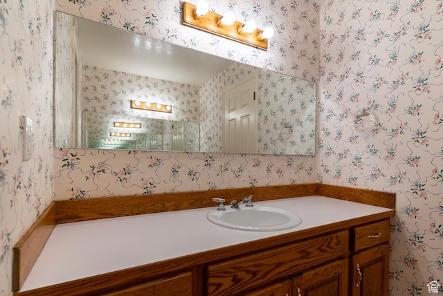 bathroom with wallpapered walls and vanity