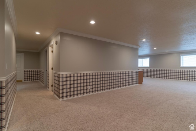 basement with carpet, ornamental molding, recessed lighting, and a wainscoted wall