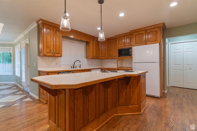 kitchen with white appliances, tile counters, a kitchen island, ornamental molding, and brown cabinets