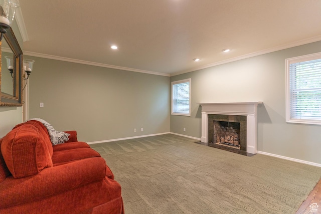 carpeted living area featuring baseboards, a fireplace with flush hearth, ornamental molding, and recessed lighting