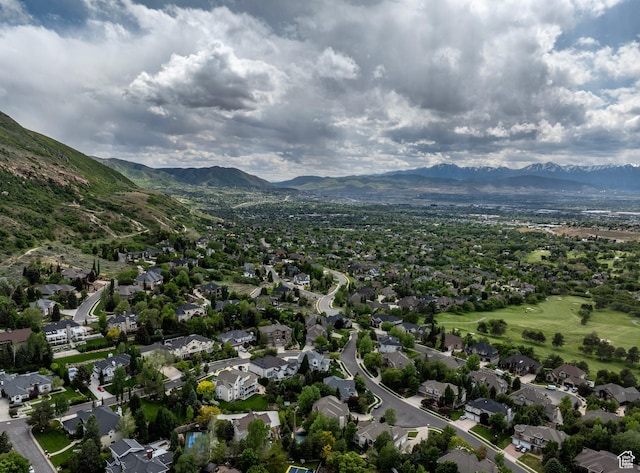 aerial view of property's location with a mountain backdrop and nearby suburban area