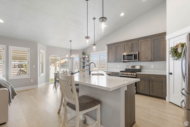541 W 1960 N, Tooele, UT 84074 - kitchen featuring a sink, stainless steel appliances, light countertops, light wood-style floors, and a breakfast bar area