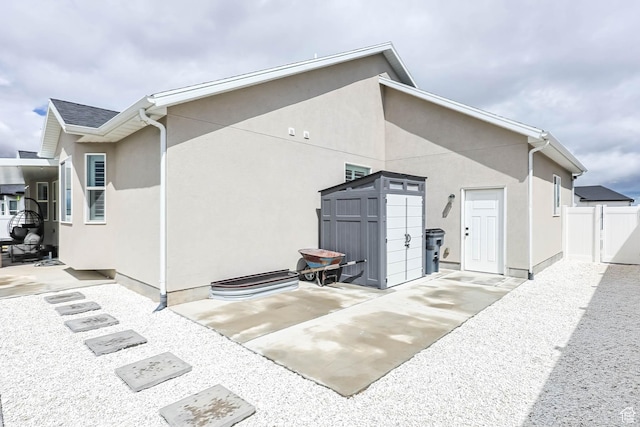 541 W 1960 N, Tooele, UT 84074 - back of house with a patio area, a storage unit, fence, stucco siding, and an outbuilding