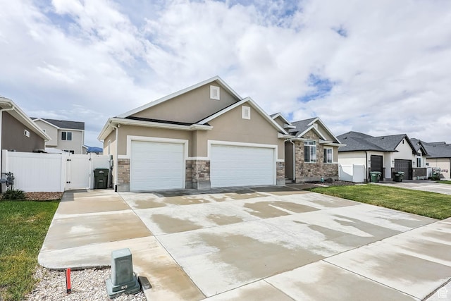 541 W 1960 N, Tooele, UT 84074 - view of front of home with a gate, stucco siding, stone siding, an attached garage, and driveway