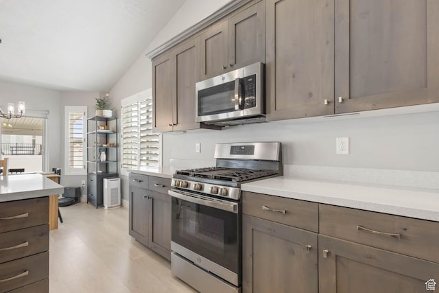 541 W 1960 N, Tooele, UT 84074 - kitchen with stainless steel appliances, a chandelier, light countertops, light wood-type flooring, and vaulted ceiling