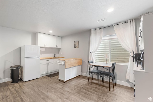 541 W 1960 N, Tooele, UT 84074 - kitchen featuring freestanding refrigerator, wooden counters, light wood-style flooring, white cabinetry, and recessed lighting