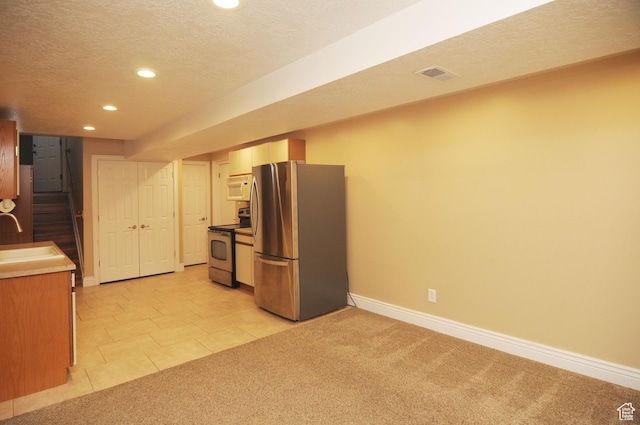 kitchen with appliances with stainless steel finishes, recessed lighting, baseboards, a sink, and a textured ceiling
