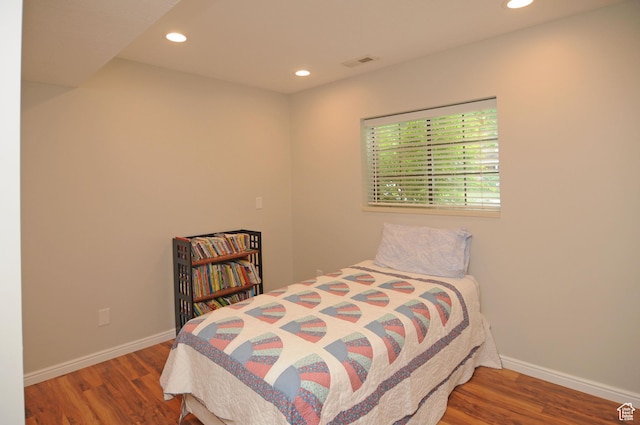 bedroom with wood finished floors, recessed lighting, and baseboards