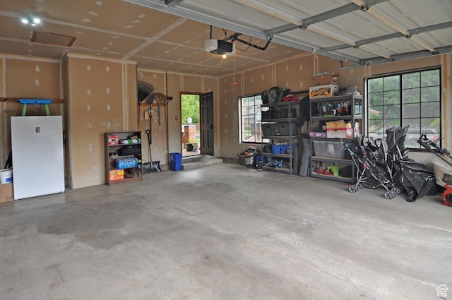 garage featuring a garage door opener and freestanding refrigerator