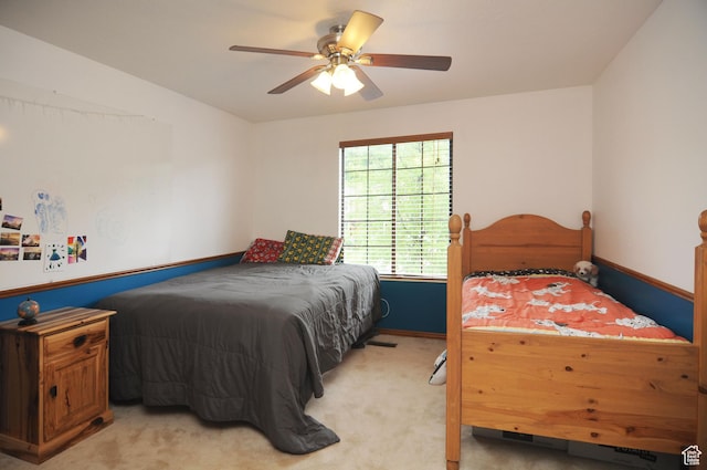 bedroom featuring light colored carpet, a ceiling fan, and baseboards