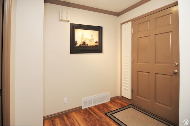 entryway with ornamental molding, dark wood-type flooring, and baseboards