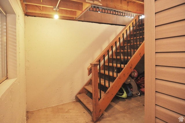 stairs with unfinished concrete flooring