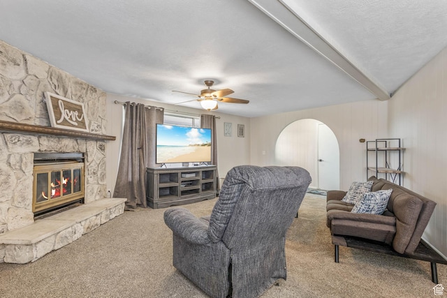 396 S 100 E, Tooele, UT 84074 - living room with carpet, arched walkways, a ceiling fan, a stone fireplace, and a textured ceiling