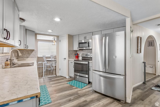 396 S 100 E, Tooele, UT 84074 - kitchen featuring appliances with stainless steel finishes, a sink, light countertops, decorative backsplash, and a textured ceiling
