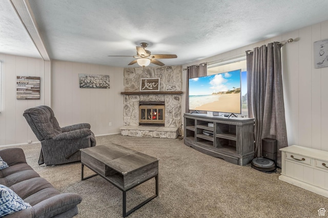 396 S 100 E, Tooele, UT 84074 - carpeted living area with ceiling fan, a stone fireplace, a textured ceiling, and wooden walls