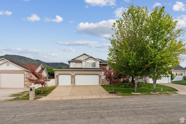 4948 S 1150 E, Ogden, UT 84403 - view of front of house with driveway, a front lawn, a mountain view, and a garage
