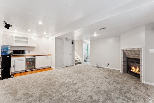 4948 S 1150 E, Ogden, UT 84403 - unfurnished living room featuring wine cooler, light colored carpet, bar, stairs, and recessed lighting