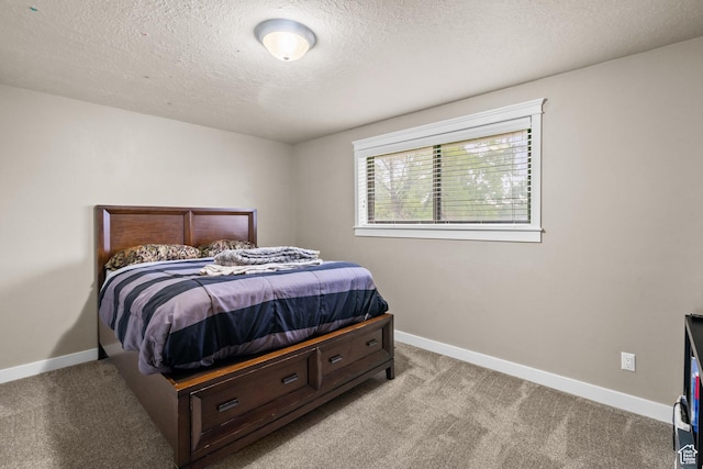 bedroom with light carpet, baseboards, and a textured ceiling