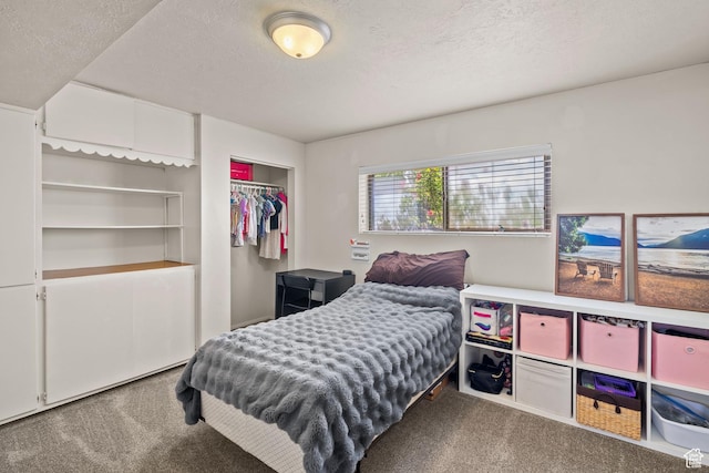 carpeted bedroom with a textured ceiling and a closet