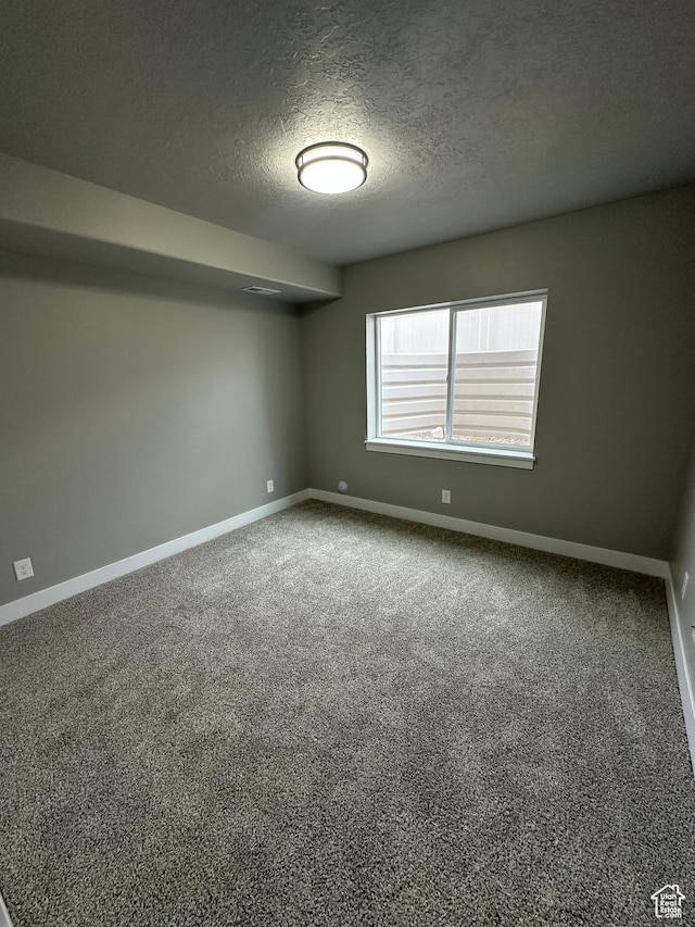 unfurnished room featuring baseboards, a textured ceiling, and carpet floors