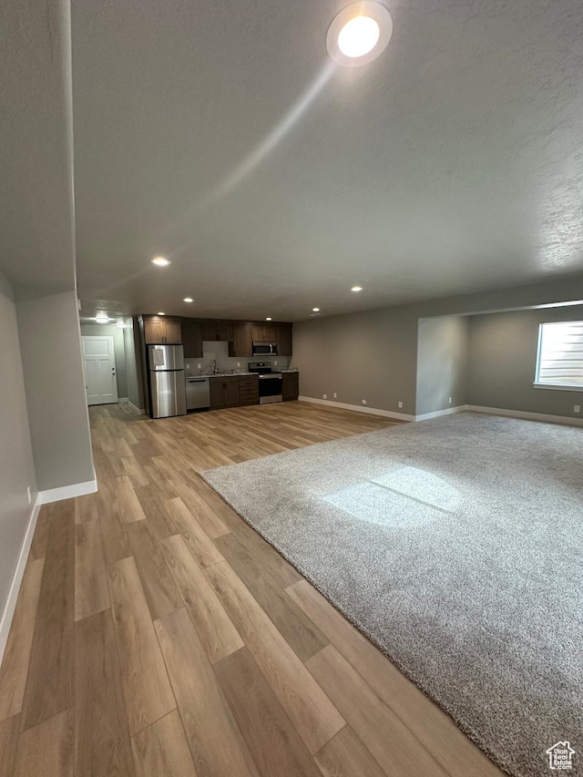 unfurnished living room featuring baseboards, light wood-style floors, and recessed lighting