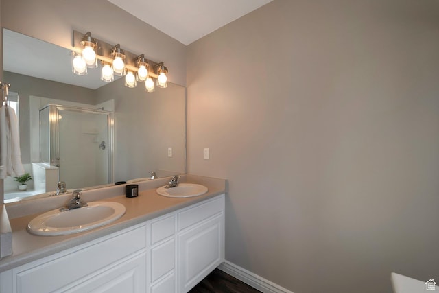 full bathroom featuring a stall shower and double vanity