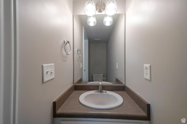 bathroom with a chandelier and vanity