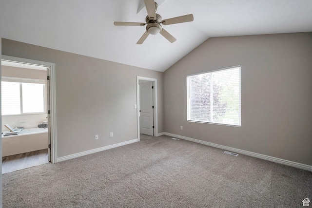 unfurnished bedroom with carpet, vaulted ceiling, baseboards, and a ceiling fan