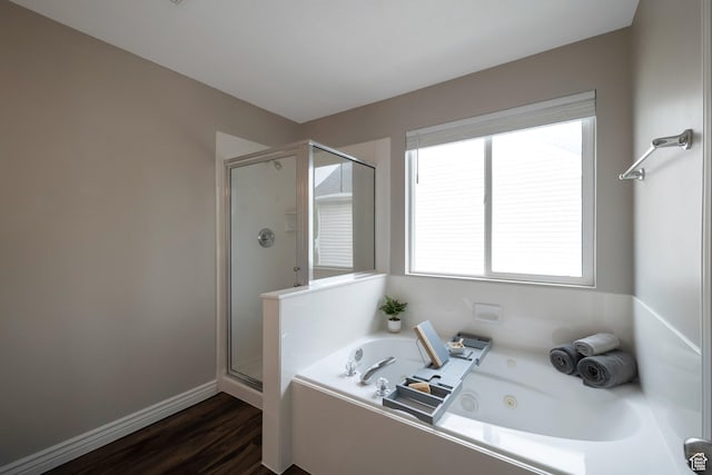 full bathroom featuring a shower stall, a jetted tub, wood finished floors, and baseboards