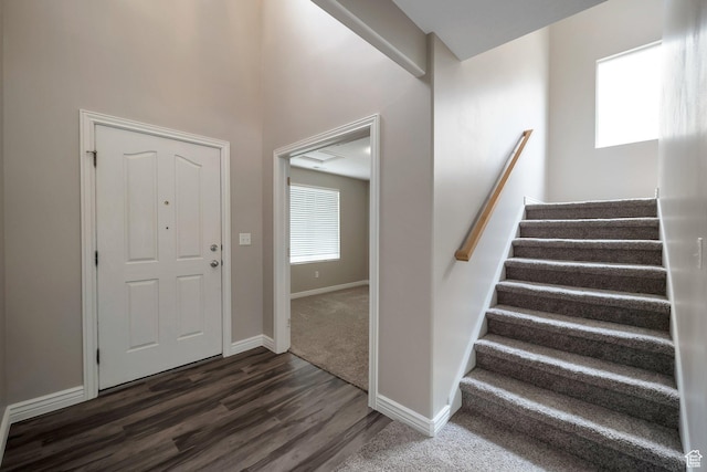 entrance foyer featuring stairs, dark wood finished floors, and baseboards