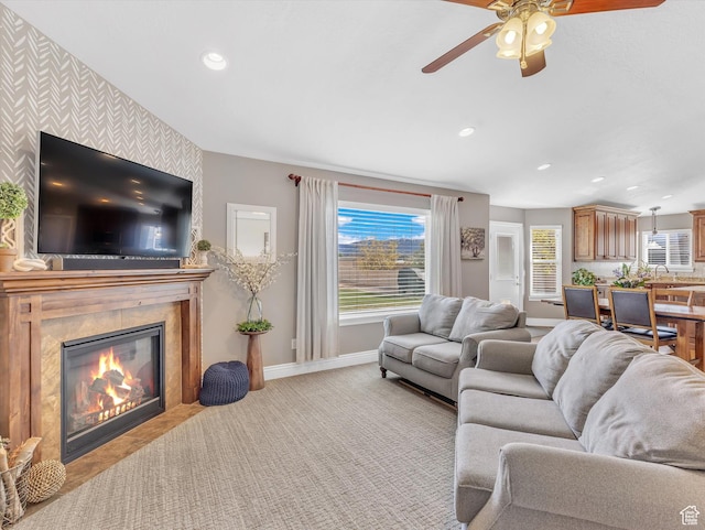 living room with baseboards, a ceiling fan, recessed lighting, a high end fireplace, and light carpet