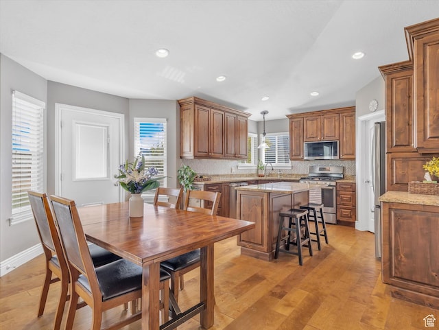 dining room with light wood-style floors, recessed lighting, and baseboards