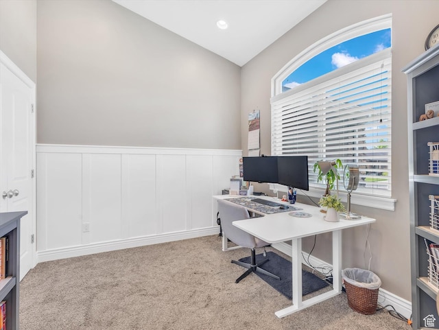 office featuring carpet floors, a wainscoted wall, lofted ceiling, and a decorative wall