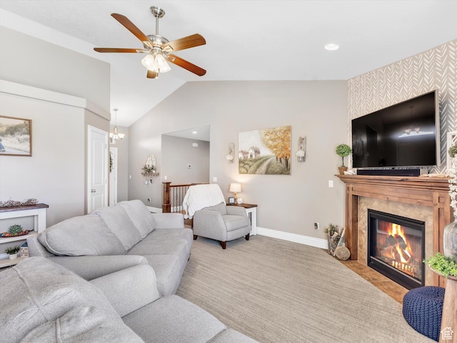 living room with baseboards, a premium fireplace, ceiling fan, vaulted ceiling, and carpet floors