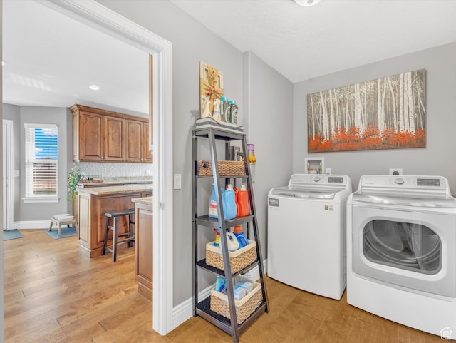 washroom with washing machine and clothes dryer, light wood-type flooring, baseboards, and recessed lighting
