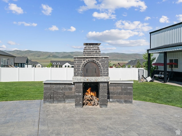 view of patio / terrace with an outdoor brick fireplace and a mountain view