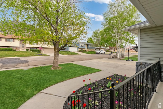 view of green lawn with a residential view