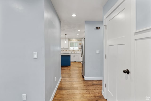 corridor with recessed lighting, wood finished floors, and baseboards