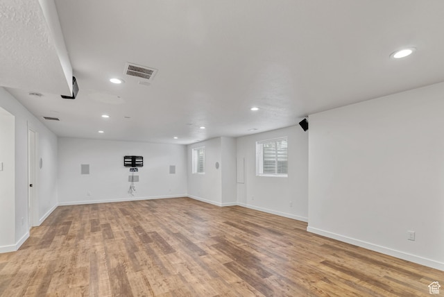 spare room featuring recessed lighting, light wood-type flooring, and baseboards