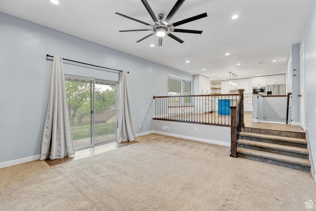 unfurnished living room featuring a ceiling fan, light colored carpet, recessed lighting, and baseboards