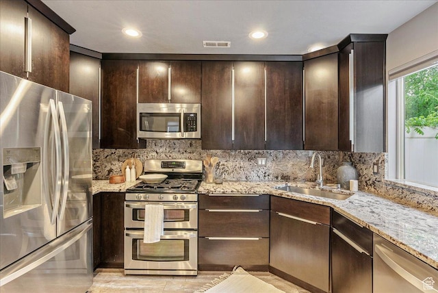 59 W 600 N, Farmington, UT 84025 - kitchen with stainless steel appliances, a sink, dark brown cabinetry, light stone countertops, and recessed lighting