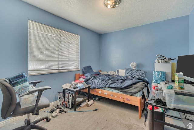 carpeted bedroom featuring a textured ceiling, baseboards, and an office area